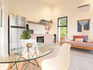 Bright living room in Villa 1 with jungle views and sliding glass doors