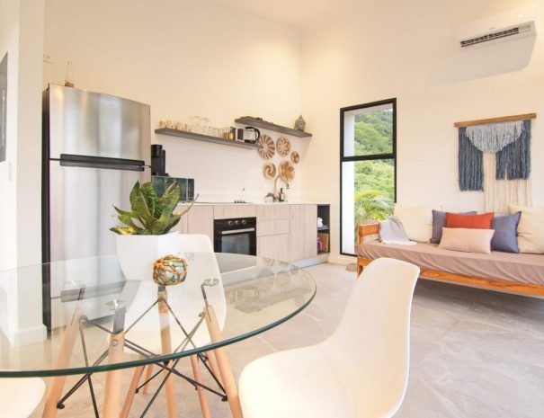 Bright living room in Villa 1 with jungle views and sliding glass doors